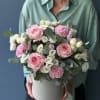 Pink and white flowers arranged in a round hatbox