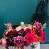 Floral arrangement in a white pumpkin with pink and burgundy blooms