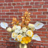 White and yellow roses with orange orchids in a gold vase