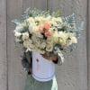 Large bouquet of cream and blush roses in a white hatbox