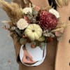 Autumn bouquet with chrysanthemums and a small pumpkin in a white bucket