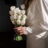 Woman holding a bouquet of white tulips