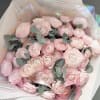 Bouquet of pale pink ranunculus with eucalyptus and pink ribbon