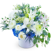 White lilies and roses in a white vase with blue hydrangea accents
