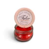 Red scented candle in a glass jar with a lid