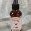 Amber room spray bottle with a black pump and pink label
