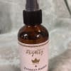 Amber room spray bottle with a pink label and black spray top