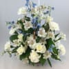 White roses, alstroemeria, and blue flowers in a basket arrangement