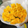 Bouquet of yellow roses wrapped in white paper