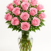 Pink roses arranged in a clear glass vase with small white filler flowers