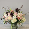 Pink roses and white blooms arranged in a square glass vase