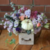 Pastel floral arrangement with a white pumpkin in a small wooden drawer box