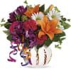 Bouquet of orange lilies, purple flowers, and white daisies in a decorated vase
