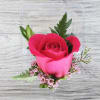 Pink rose with small pink flowers in a clear plastic box