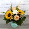 Mixed bouquet with sunflowers, roses, and white blooms in a blue vase