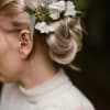 Woman wearing a white floral hairpiece in her blonde updo