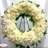Creamy white floral wreath with roses and orchids on a stand