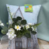 A soft-colored pillow with a picture of a church and includes a