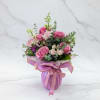 Pink rose bouquet wrapped in lavender paper with a ribbon