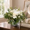 White roses and hydrangeas in a clear square vase