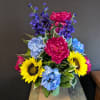 Colorful bouquet with sunflowers, blue hydrangeas, and pink peonies in a vase
