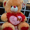 Plush teddy bear holding a heart with "I Love You" text