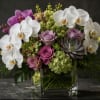 Large white Phalaenopsis orchids anchor this sophisticated floral arrangement, making it an