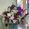 Large bouquet of pink, white, and purple flowers in a blue hat box