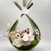 Floral arrangement in a curved green frame with pink and white blooms