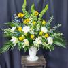 Large white vase arrangement with yellow and white flowers