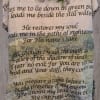 Floral arrangement on a Psalm-printed blanket hanging on a wooden wall