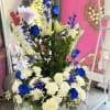 Vivid blue roses rise beside pure white lilies and roses in this