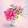 Pink and white flowers arranged in a small metal bucket