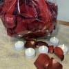 Bag of red rose petals with small LED tealight candles