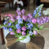 Pink and blue mixed flowers arranged in a white vase