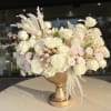 Cream and blush rose arrangement in a gold pedestal vase