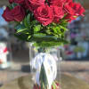 Bouquet of red roses in a clear glass vase with a white ribbon