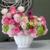 Pink and white floral arrangement in a white vase