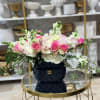 Bright pink and white roses mingle with pale lisianthus, white hydrangea and