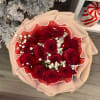 Bouquet of red roses with white baby's breath in pink wrapping