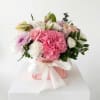 Pink and white mixed flower arrangement in a pink box with a white ribbon