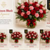 Red roses and pink carnations arranged in a clear glass vase with a ribbon.