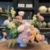 Pastel floral arrangement in a white pedestal vase