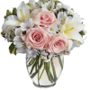 Pink roses and white lilies in a clear glass vase