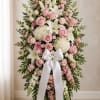 Standing floral spray with pink roses, white lilies, and a white ribbon bow