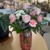 Pale pink roses and ruffled pink carnations take center stage in this