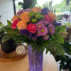 Peach roses and bright pink carnations mingle with pink daisy-like blooms in