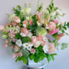 Large pastel bouquet with pink roses, white blooms, and green foliage in a white box