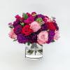 A stunning arrangement of vibrant roses and carnations in rich hues, creating