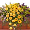 Bright, vivid yellow and purple flowers create a memorable casket spray.